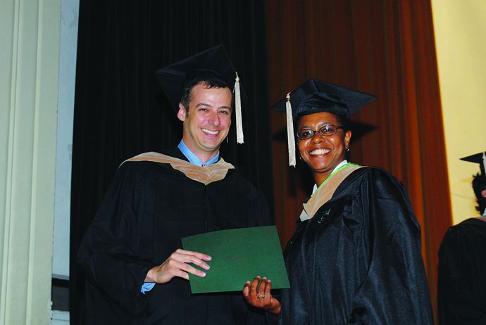 Aisha Acres, right, received a TABA Community Service Award from TABA President Jerry Lenaz at this year's commencement ceremony