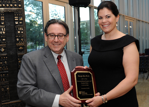 Dean Ira Solomon, left, presents Jasmijn Bol with a plaque recognizing her investiture as the inaugural PricewaterhouseCoopers, LLP Faculty Fellow in Accounting.