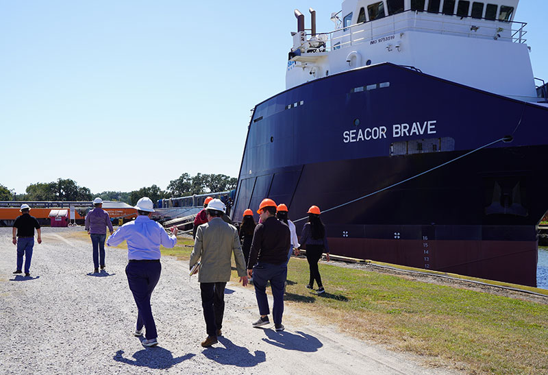 Burkenroad Reports analysts walk beside ship at Seacor Marine