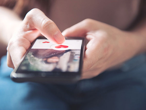 stock photo of user's hands on a dating app.