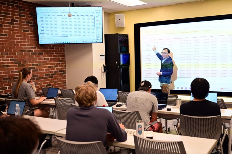 Professor teaching a data analytics course in a Goldring/Woldenberg Business Complex classroom.
